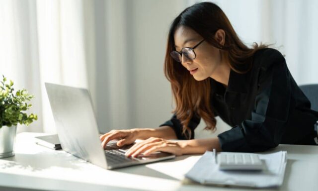 Local business owner working on a laptop in an office setting