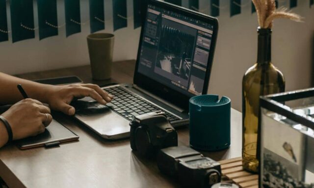 Professional documenting real work by reviewing project photos and notes on a laptop